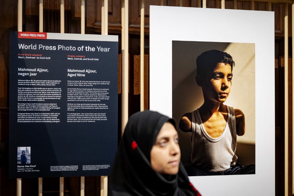 La fotógrafa palestina Samar Abu Elouf posa junto a su foto